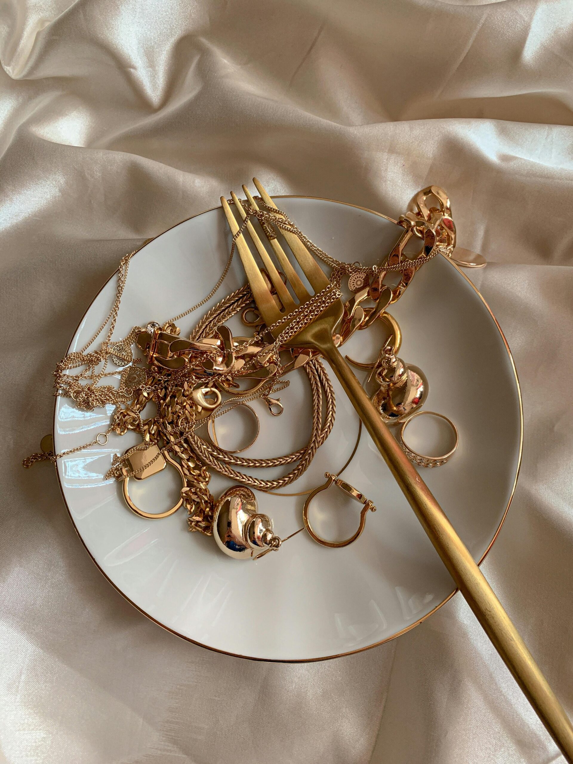 A collection of luxurious gold jewelry elegantly displayed on silk fabric for a sophisticated look.